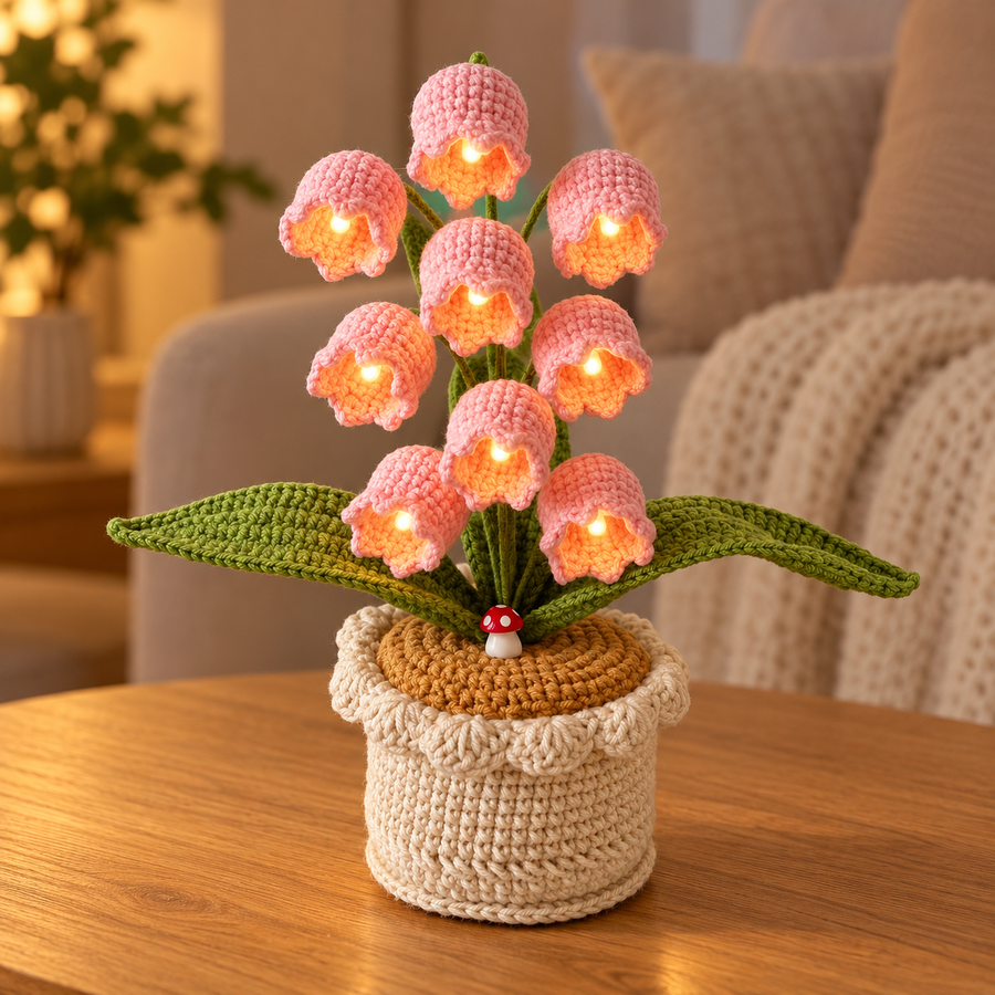 Blush Pink lily of the valley crochet lamp with warm-white lights on an oak table