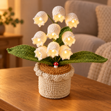 Ivory lily of the valley crochet lamp with warm-white lights on an oak table